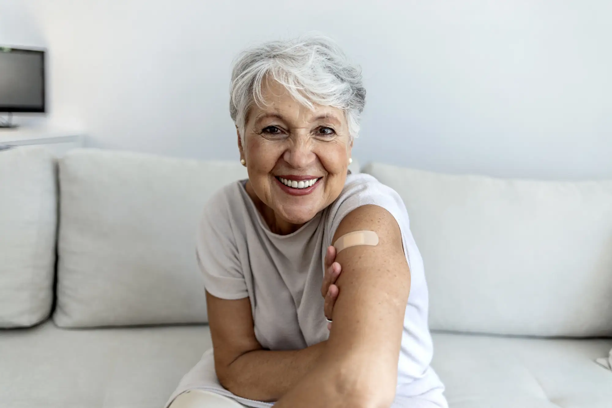 senior woman with a bandaid on her arm after receiving the flu shot